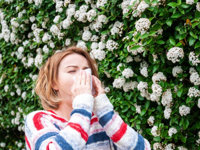 woman sneezing due to pollen